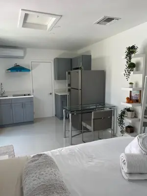 a white kitchen with a bed and a refrigerator at Studio close to airport in Dania Beach