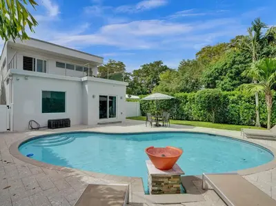a swimming pool in front of a house at Contemporary 2BR Home with Pool & BBQ Access in Fort Lauderdale