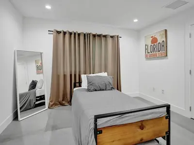 a bedroom with a bed and a large mirror at Contemporary 2BR Home with Pool & BBQ Access in Fort Lauderdale