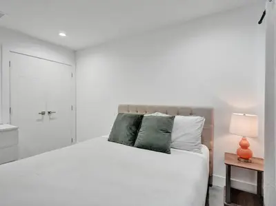 a bedroom with a white bed and a bathroom at Contemporary 2BR Home with Pool & BBQ Access in Fort Lauderdale