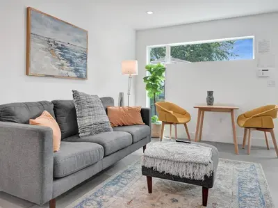 a living room with a gray couch and a table at Contemporary 2BR Home with Pool & BBQ Access in Fort Lauderdale