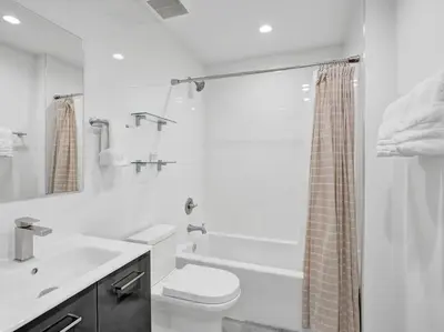 a white bathroom with a toilet and a sink at Contemporary 2BR Home with Pool & BBQ Access in Fort Lauderdale