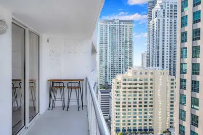 a balcony with two bar stools and some tall buildings at Beautiful 1 Bed 1 Bath • Brickell • Bay View in Miami
