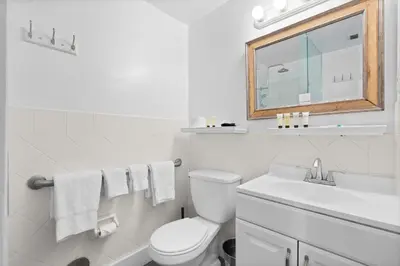 a white bathroom with a toilet and a sink at 1 Bedroom Jr Suite - Ocean Drive & 6th Str in Miami Beach