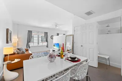 a white kitchen with a white table and chairs at 1 Bedroom Jr Suite - Ocean Drive & 6th Str in Miami Beach