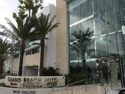 a building with palm trees in front of it at Grand Beach Hotel Surfside West in Miami Beach