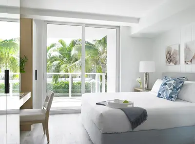 a white bedroom with a large bed and a window at Grand Beach Hotel Surfside West in Miami Beach