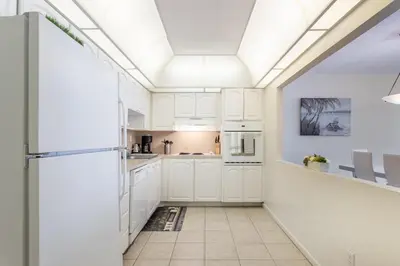 a kitchen with white cabinets and a ceiling at Sunny Isles Ocean Reserve Condo Apartments in Miami Beach