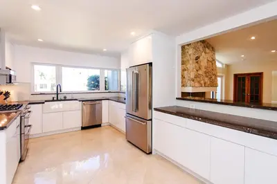 a kitchen with white cabinets and a stainless steel refrigerator at Amazing Villa WALK 5 minutes to Hollywood Beach in Hollywood