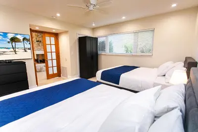 a bedroom with two beds and a television at Amazing Villa WALK 5 minutes to Hollywood Beach in Hollywood