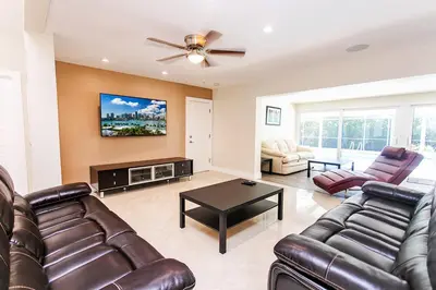 a living room with leather furniture and a flat screen tv at Amazing Villa WALK 5 minutes to Hollywood Beach in Hollywood