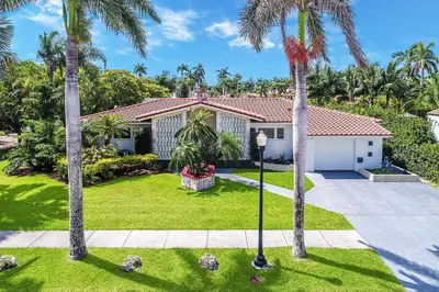 a house with palm trees in front of it at Amazing Villa WALK 5 minutes to Hollywood Beach in Hollywood