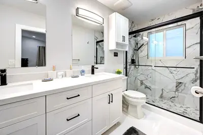 a white bathroom with a shower and a toilet at Walk to Beach Luxury 4BR & 4BA Villa Hollywood Lakes in Hollywood