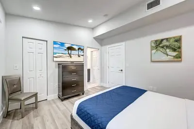 a bedroom with a bed and a desk and a chair at Walk to Beach Luxury 4BR & 4BA Villa Hollywood Lakes in Hollywood