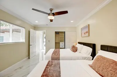 a bedroom with two beds and a ceiling fan at Breathtaking 5BR & 3BA Villa near Hollywood Beach in Hollywood