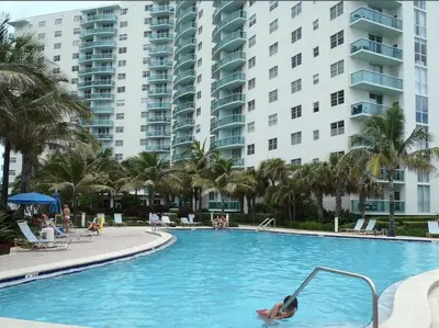 a person in a swimming pool with buildings in the background at Komffy Apt w/2 Queen Beds & Canal View at Tides in Hollywood