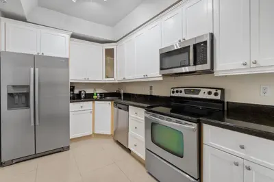 a kitchen with white cabinets and stainless steel appliances at PROMO Komffy Penthouse w King Bed and Ocean view at Tides 16th floor in Hollywood