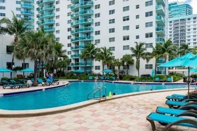 a pool at a resort with chairs and umbrellas at PROMO Komffy Home with King Bed & Ocean View at Tides 7th floor in Hollywood