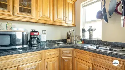 a kitchen with wooden cabinets and a sink and a microwave at Komffy Studio Waterfront w/King Bed & Free Parking in Hollywood
