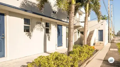 a white building with palm trees in front of it at Komffy Studio Waterfront w/King Bed & Free Parking in Hollywood