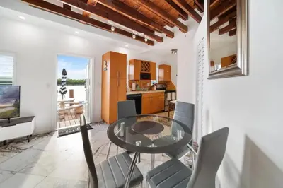 a dining room with a glass table and chairs at Waterside Escape w/Queen Bed & Free Parking in Hollywood