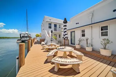 a wooden deck with benches and a boat on the water at Waterside Escape w/Queen Bed & Free Parking in Hollywood