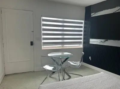 a table and a chair in a room with a window at VillaClara Studio-Little Havana in Miami