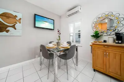 a dining room with a glass table and chairs at Komffy Intercoastal retreat King Bed, Free Parking in Hollywood