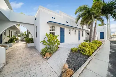 a white house with palm trees and a driveway at Waterside Studio w/ King bed - Hollywood in Hollywood