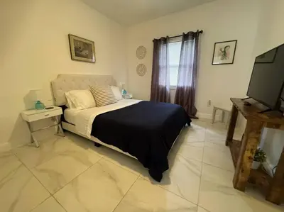 a bedroom with a bed and a flat screen tv at Brickell + Wynwood Wonderland: Spacious 6BR Home in Miami