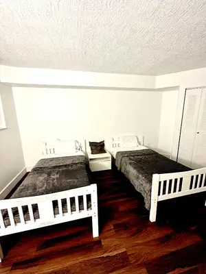 two beds in a room with white walls and wooden floors at Private bedroom 1 block from Downtown Miami in Miami