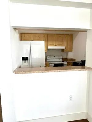 a kitchen with wooden cabinets and white appliances at Private bedroom 1 block from Downtown Miami in Miami
