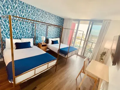 a bedroom with a bed and a desk and a window at 2BR-2BA Oasis W-Stunning Views at Beachwalk in Hallandale Beach