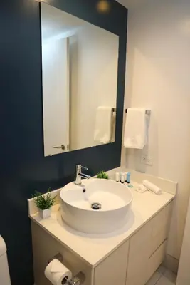 a bathroom with a sink and a large mirror at Beachwalk Studio W-Kitchenette Beach Pool Gym in Hallandale Beach
