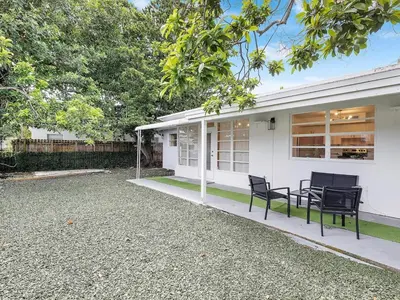 a white house with two chairs and a table at 3BR Newly Renovated In Miami 15 Min To Beach in Miami