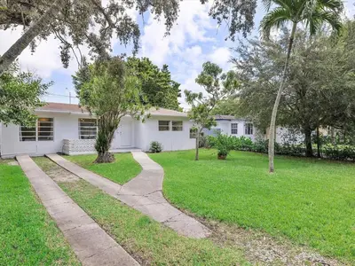 a white house with a lawn and trees at 3BR Newly Renovated In Miami 15 Min To Beach in Miami