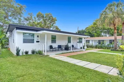 a white house with a lawn in front of it at Hallandale Beach Modern apartment Chic Backyard in Hallandale Beach