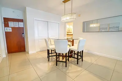a dining room with a table and white chairs at Amazing apartment by the Ocean in Hollywood