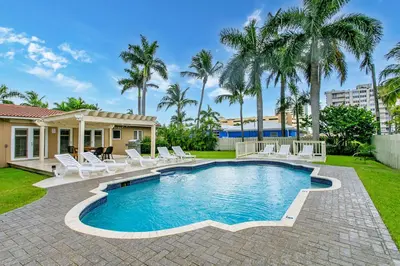 a pool with white chairs and palm trees at Walk to Beach Luxury 5BR & 3BA Villa Hollywood Lakes in Hollywood