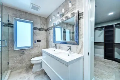 a bathroom with a sink and a toilet and a mirror at Luxury 5BR & 3BA Villa Walk to Hollywood Beach in Hollywood