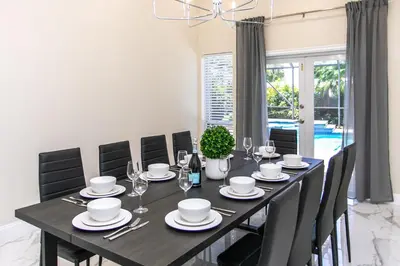 a dining room with a black table and chairs at Fabulous 5BR & 3BA Villa near Hollywood Beach in Hollywood