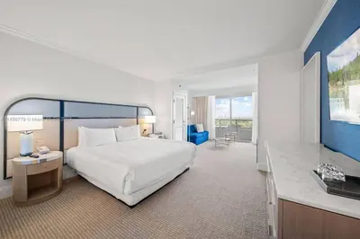 a bedroom with a large white bed and a desk at Fontainebleau Miami Beach Junior Suite in Miami Beach