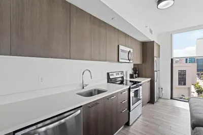a kitchen with wooden cabinets and a large window at Majestic unit in the heart of Downtown Miami in Miami