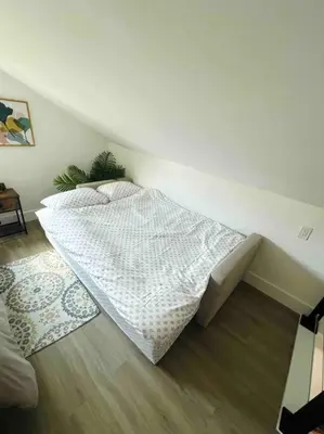 a white bed in a room with a wooden floor at La Casita in Miami