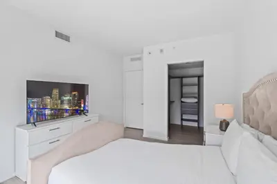 a white bedroom with a bed and a tv at Sublime property in the heart of downtown Miami in Miami