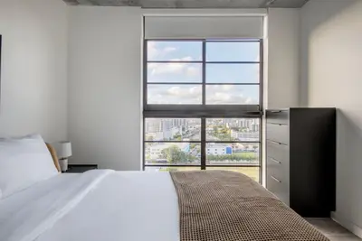 a bedroom with a bed and a large window at Blueground Wynwood pool gym nr Design Dist MIA-99 in Miami