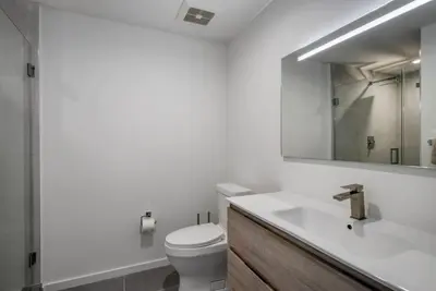 a bathroom with a toilet and a sink and a mirror at Blueground Wynwood pool gym nr Design Dist MIA-99 in Miami