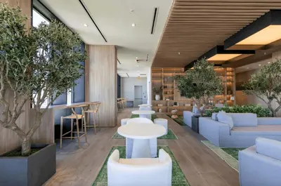 a lobby with white tables and chairs and trees at Blueground Wynwood pool gym nr Design Dist MIA-99 in Miami