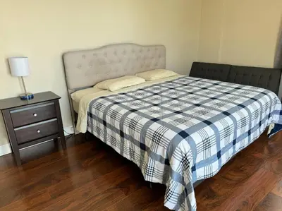 a bedroom with a bed with a plaid blanket and a night stand at Lovely 2 bedroom with side ocean view in Hollywood