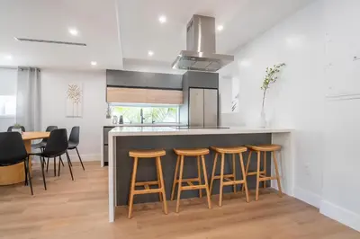 a kitchen with a bar with stools and a table at 5BR HotTubPoolTableMiniGolf 7 min to Wynwood in Miami